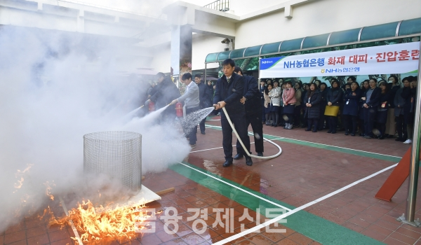 12일 서울 용산구에 위치한 농협은행 용산별관에서 농협은행 직원들이 재난상황을 대비한 화재 진압·대피 훈련을 실시하고 있다.