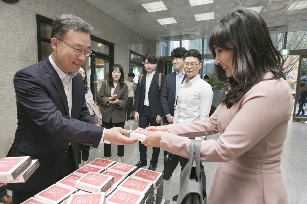 케이뱅크 심성훈 은행장(왼쪽)이 출범 1주년을 맞아 서울 충정사옥 고객센터에서 출근하는 직원들에게 기념 떡을 나눠주고 있다.