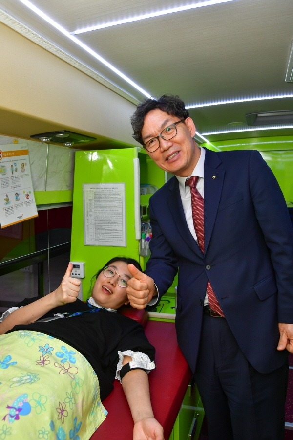 지난 13일 서울시 중구 농협은행 본점에서 진행된 '생명사랑 헌혈봉사'행사에서 이대훈 농협은행장(오른쪽)이 헌혈중인 직원들을 찾아가 격려하고 있다.