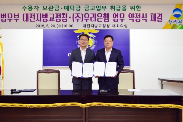 허정진 우리은행 기관그룹부행장(오른쪽)이 최강주 대전지방교정청장과 업무 협약을 체결하고 있다.