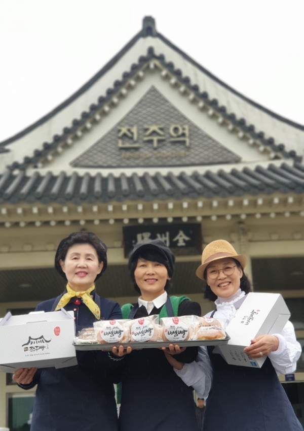 장윤영 전주비빔빵 대표(가운데)r가 10일 직원들과 전주역사 앞에서 전주비빔빵을 들어 보이고 있다.