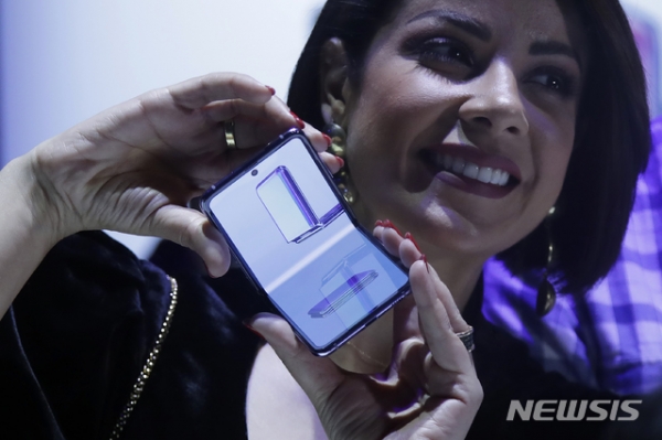 지난해 미 캘리포니아주 샌프란시스코 팰리스 오브 파인 아트에서 '삼성 갤럭시 언팩 2020' 행사가 열려 한 여성이 폴더블폰 '갤럭시Z 플립'을 선보이고 있다.(사진=뉴시스)