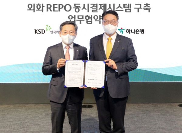 한국예탁결제원 이명호 사장(오른쪽)이 하나은행 박성호 은행장과 외화 레포 동시결제 시스템 구축을 위한 업무협약을 체결하고 기념촬영을 하고 있다.