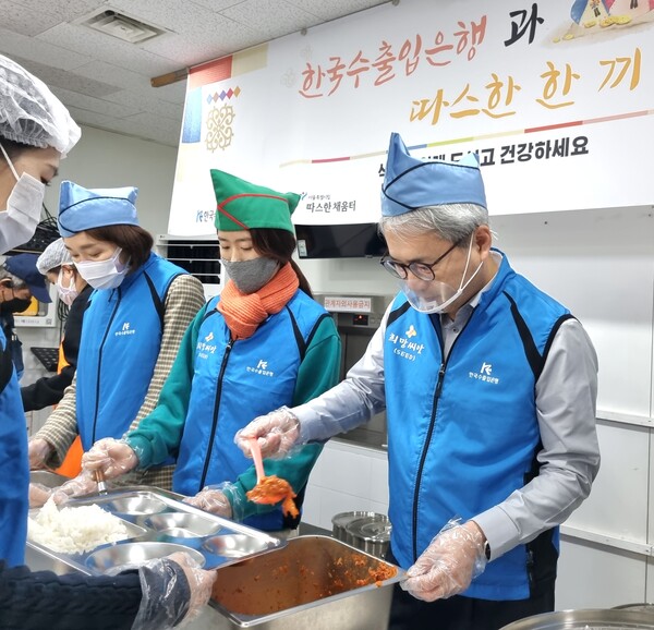 31일 윤희성 한국수출입은행장(오른쪽)과 임직원들이 노숙인 대상 무료 급식소 따스한 채움터에서 배식 봉사를 하고 있다. (사진=한국수출입은행 제공)  